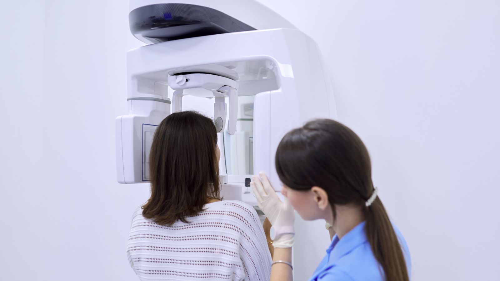 Arkasını dönmüş hasta, 3D çene ve diş tomografisi cihazında – detaylı ağız ve çene yapısı görüntülemesi
