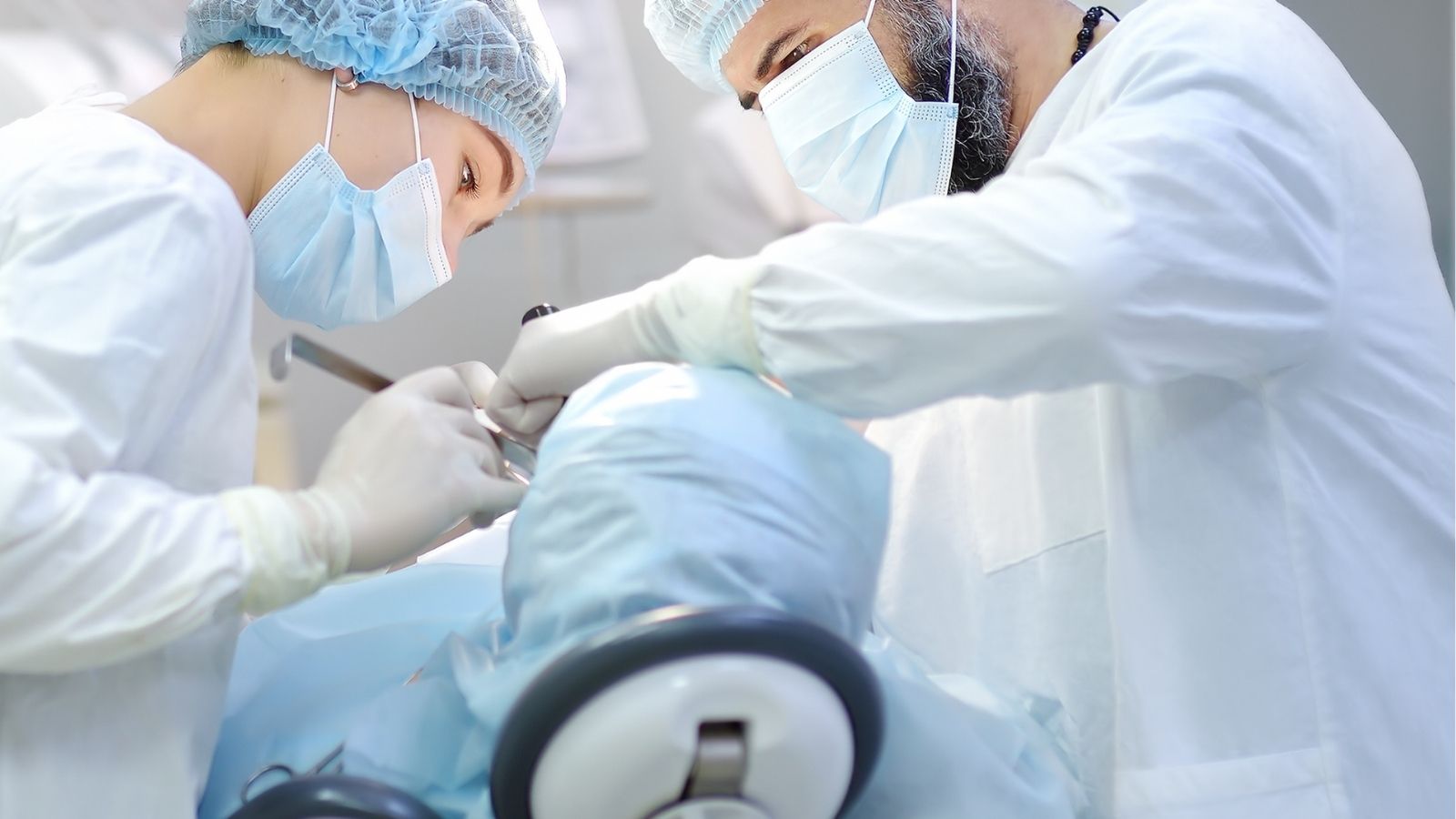 Ortognatik cerrahi kapsamında çene ameliyatı tedavisi için hasta üzerinde çalışan iki doktor